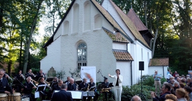 Shereen Adam und die Big Band des Polizeiorchester Niedersachsen vor der Meinerdinger St.-Georg-Kirche