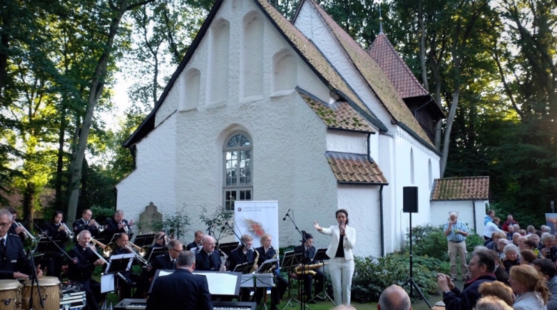 Shereen Adam und die Big Band des Polizeiorchester Niedersachsen vor der Meinerdinger St.-Georg-Kirche